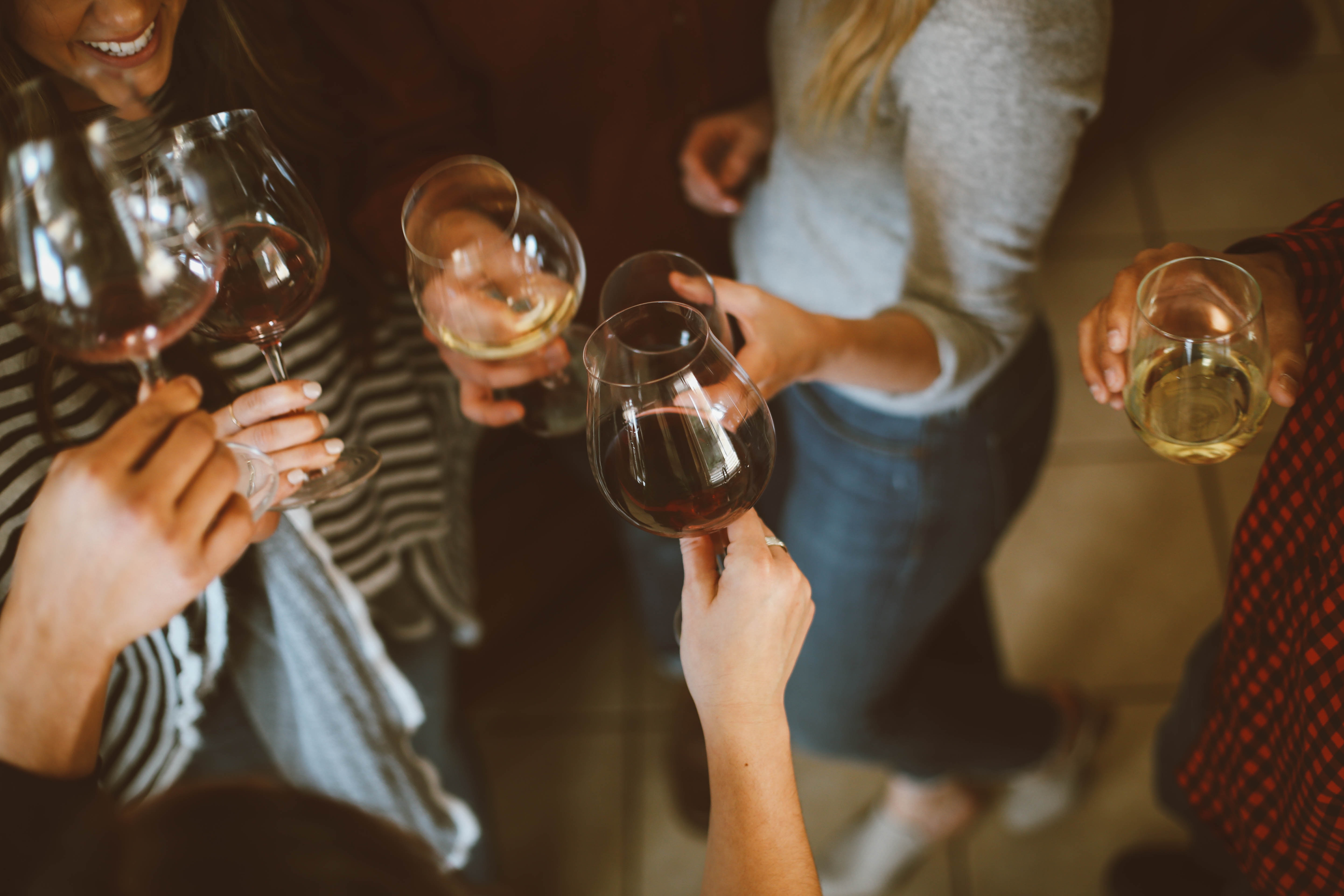 Group of people holding wine glasses in a toast