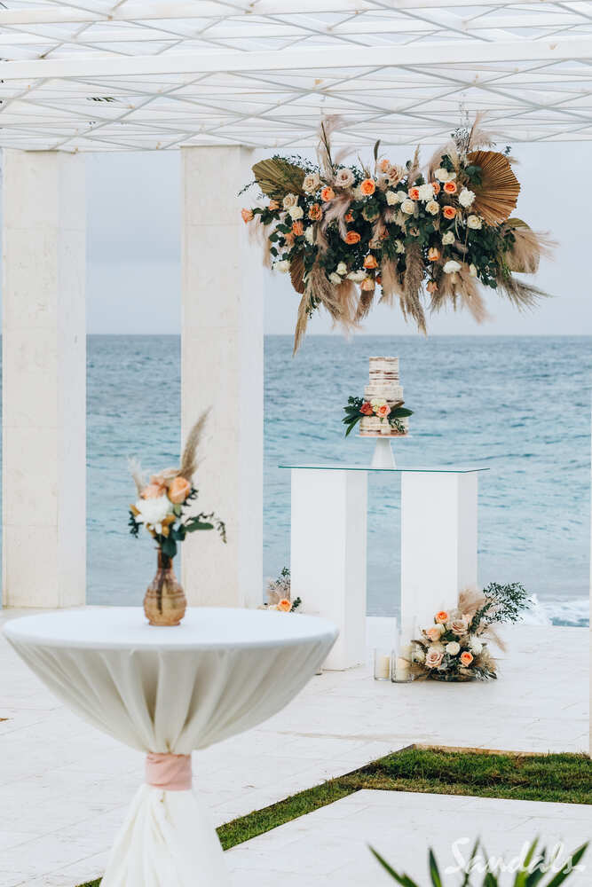 Wedding gazebo with hanging flowers and flowers on pedestals