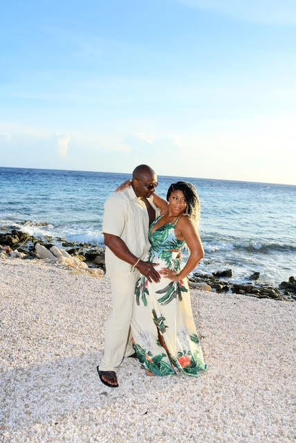 Photo of black couple standing on beach