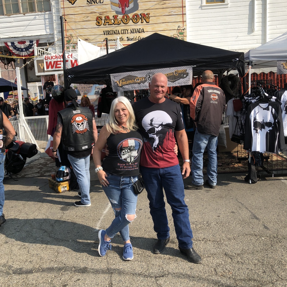 Man and women at motorcycle rally in Virginia City, NV in front of Virginia City Motorcycle Company vendor tent