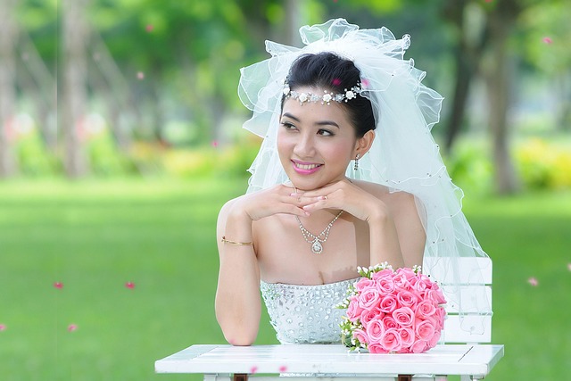Asian bride sitting on a bench with pink bouquet